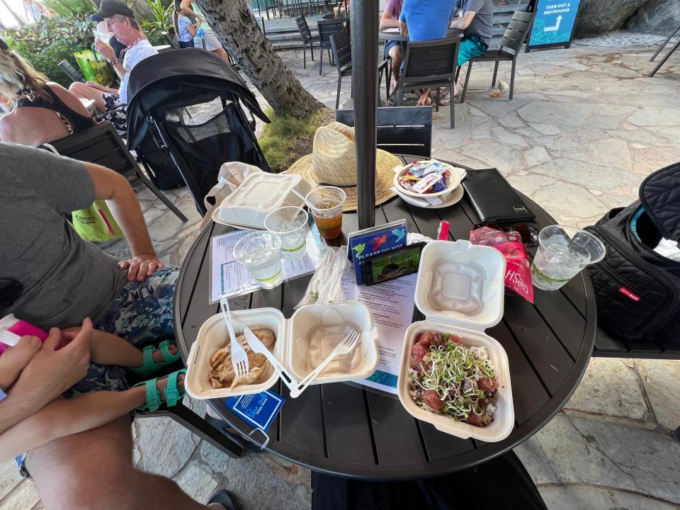 A table full of food in to-go boxes.