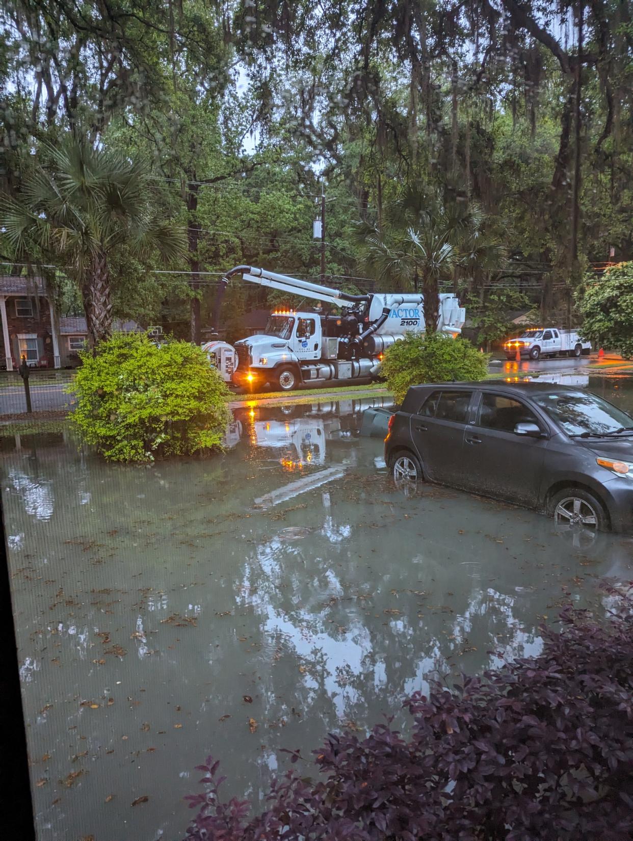 City of Tallahassee crews work to drain the flooding taking over Kelly Manu's front yard.