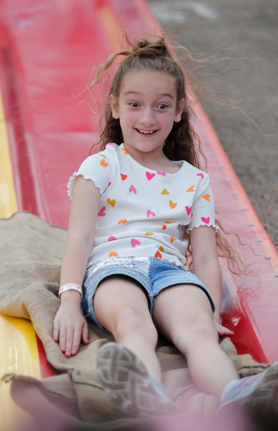 Eight-year-old Joleigh Cruce, of Lubbock, shows her excitement on the Funs Slide during preview night at the Panhandle South Plains Fair Thursday, September 21, 2023.
