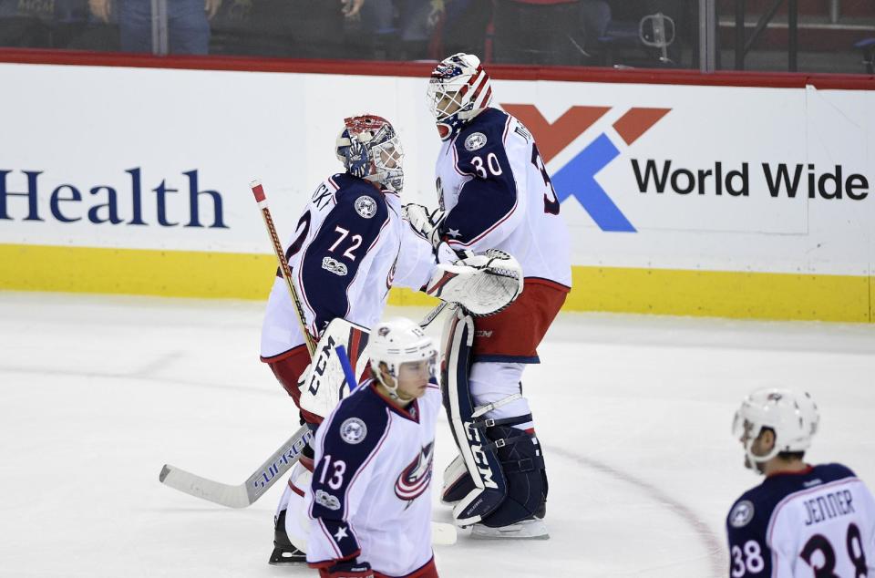 Columbus Blue Jackets goalie Sergei Bobrovsky (72), of Russia, skates toward the bench as he is replaced by goalie Curtis McElhinney (30) during the third period of an NHL hockey game against the Washington Capitals, Thursday, Jan. 5, 2017, in Washington. Blue Jackets right wing Cam Atkinson (13) and center Boone Jenner (38) look on. (AP Photo/Nick Wass)