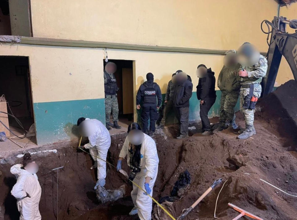 Police digging up the ground in a warehouse where human remains were found. 