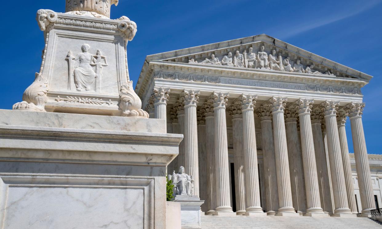 FILE - The U.S. Supreme Court is seen, with a carving of Justice in the foreground, April 19, 2023, in Washington. A Black Ohio woman who miscarried in her bathroom has been charged with abuse of a corpse and awaits grand jury action. Her case has sparked a national firestorm over the plight of pregnant women, especially women of color, following the U.S. Supreme Court’s decision to overturn Roe v. Wade. (AP Photo/Jacquelyn Martin, File)