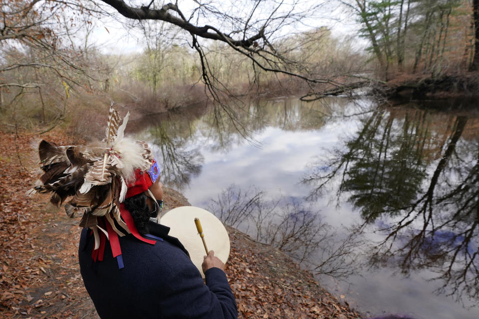 Larry Fisher, chief sachem of the Mattakeeset Massachuset tribe, drums at the bank of the Taunton River at Titicut Indian Reservation, Friday, Nov. 27, 2020, in Bridgewater, Mass. A rift has been widening between Native American groups in New England over a federal reservation south of Boston where one tribe is planning to build a $1 billion casino. The Mattakeeset Massachuset tribe contend the Mashpee Wampanoag tribe doesn't have exclusive claim to the lands under their planned First Light casino in the city of Taunton, as they've argued for years. (AP Photo/Elise Amendola)