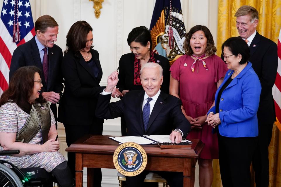 President Joe Biden hands out a pen after signing the COVID-19 Hate Crimes Act, in the East Room of the White House, on, May 20, 2021, in Washington. Clockwise from left, Sen. Tammy Duckworth, R-Ill., Sen. Richard Blumenthal, D-Conn., Vice President Kamala Harris, Rep. Judy Chu, D-Calif., Rep. Grace Meng, D-N.Y., Rep. Don Beyer, D-Va., and Sen. Mazie Hirono, D-Hawaii.