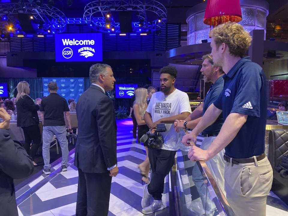University of Nevada president and former Gov. Brian Sandoval, center left, talks to wolf pack fans at the Grand Sierra Resort before a news conference Wednesday, Sept. 27, 2023, in Reno, Nev. The University of Nevada’s basketball team could have a new off-campus home by 2026 under an ambitious 10-year expansion plan that Reno’s largest hotel-casino announced Wednesday. The nearly $1 billion private capital investment will be the biggest in the city's history, according to officials of the Grand Sierra Resort. (AP Photo/Scott Sonner)