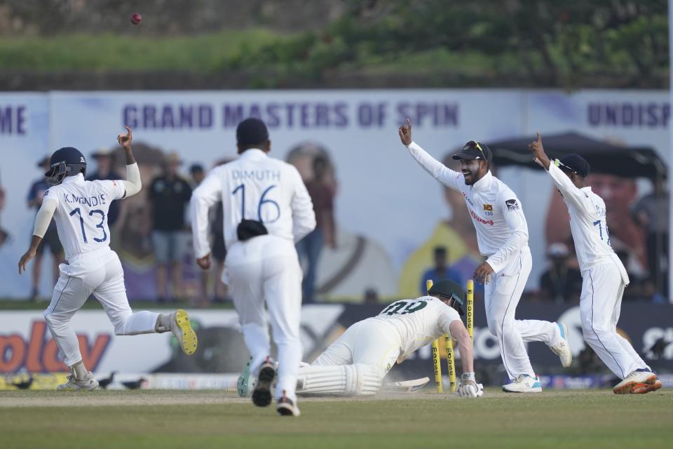 Australia's Steven Smith unsuccessfully dives back to his ground being run out as Sri Lankan players celebrate during the day one of their first test cricket match in Galle, Sri Lanka, Wednesday, June 29, 2022. (AP Photo/Eranga Jayawardena)