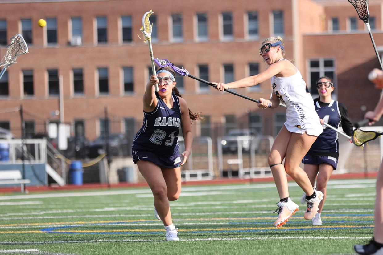 Lourdes' Taryn Satkowski takes a shot on the goal while guarded by Burke Catholic's Baylie Dow during an April 12, 2024 girls lacrosse game.