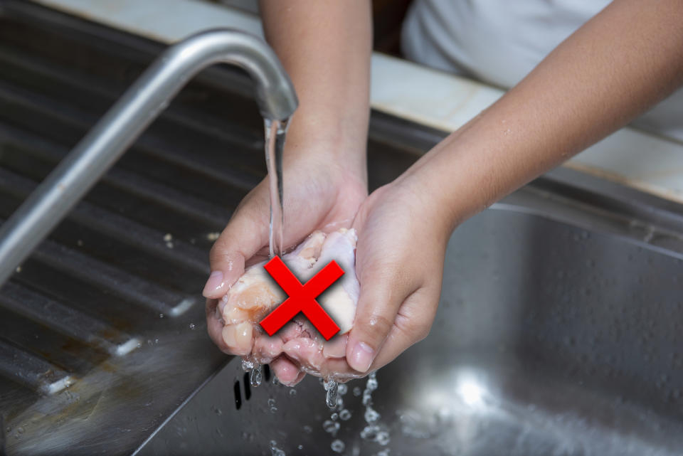 Rinsing chicken under a kitchen faucet