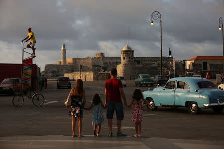 Felix Guirola, 52, rides a homemade bike with an advertising banner in Havana, Cuba, July 20, 2016. REUTERS/Alexandre Meneghini