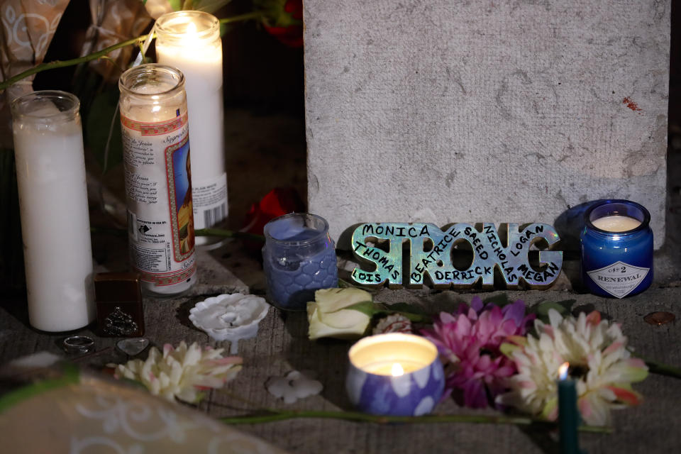 A makeshift memorial is setup outside Ned Peppers bar following a vigil at the scene of a mass shooting, Sunday, Aug. 4, 2019, in Dayton, Ohio. A masked gunman in body armor opened fire early Sunday in the popular entertainment district in Dayton, killing several people, including his sister, and wounding dozens before he was quickly slain by police, officials said. (AP Photo/John Minchillo)