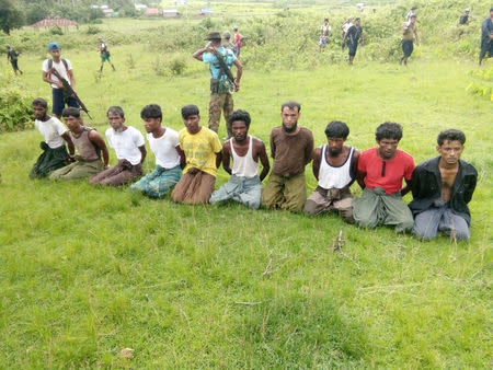 Ten Rohingya Muslim men with their hands bound kneel as members of the Myanmar security forces stand guard in Inn Din village September 2, 2017. Handout via REUTERS/Files