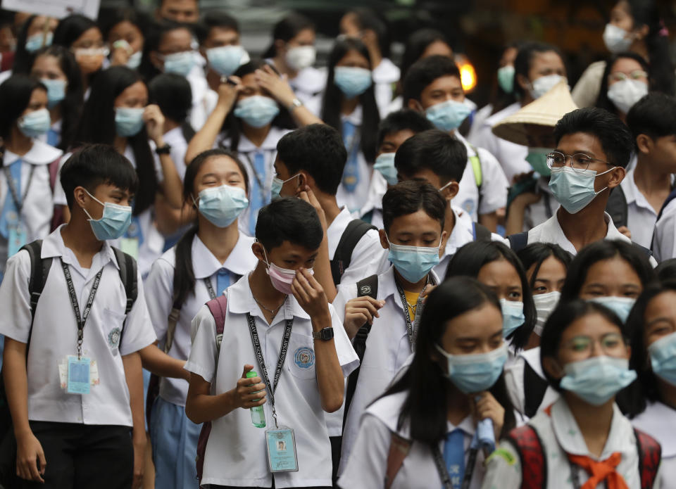Students wearing protective masks join a school activity in Manila, Philippines on Friday, Jan. 31, 2020. The World Health Organization declared the outbreak sparked by a new virus in China that has spread to more than a dozen countries a global emergency after the number of cases spiked more than tenfold in a week, including the highest death toll in a 24-hour period reported Friday. Health officials in the country recently confirmed the Philippines' first case of the new virus. (AP Photo/Aaron Favila)