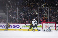 Fans celebrate after Vancouver Canucks' Quinn Hughes, left, scored against Seattle Kraken goalie Joey Daccord during the third period of an NHL hockey game Tuesday, April 26, 2022, in Vancouver, British Columbia. (Darryl Dyck/The Canadian Press via AP)