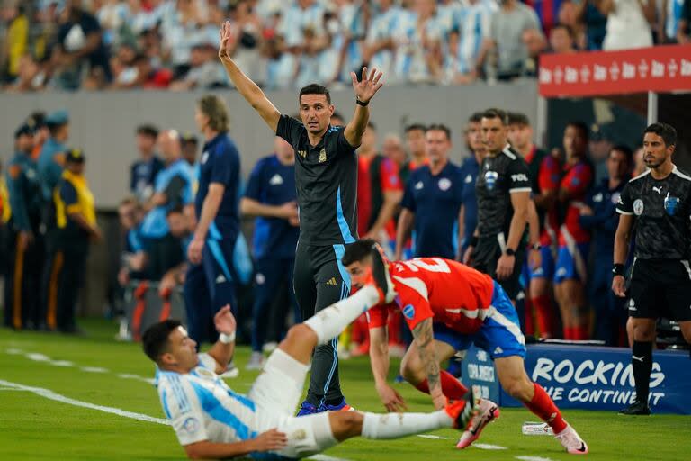 Marcos Acuña en el piso, tras el choque con Nicolás Fernández, ante la mirada de Lionel Scaloni; el seleccionador se mantiene invicto frente a Chile