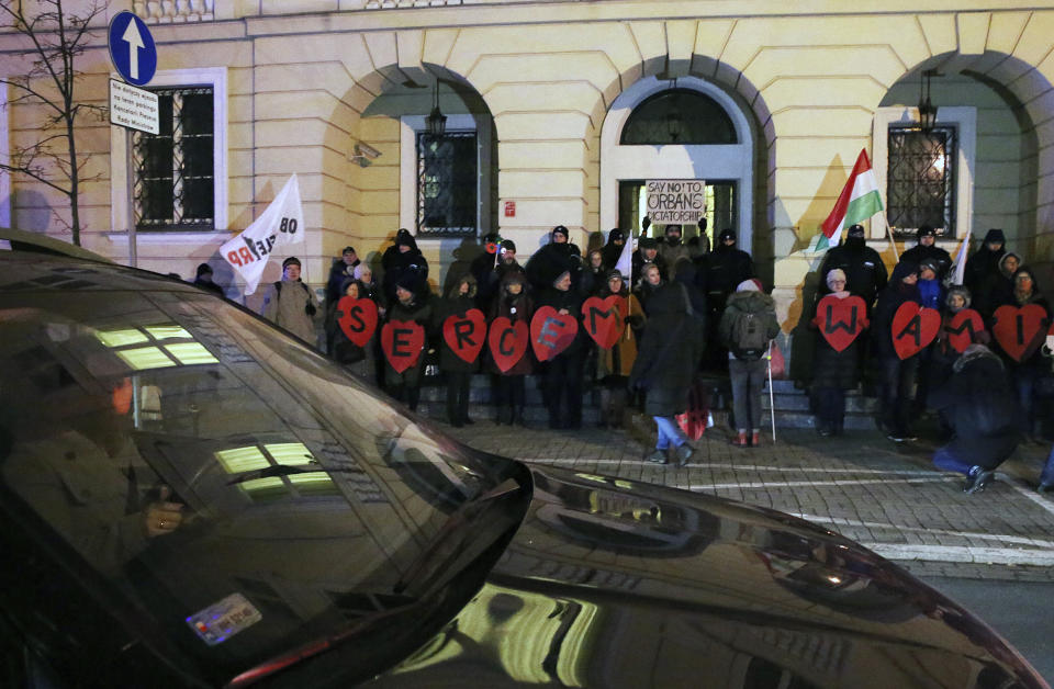 Demonstrators gather in front of the Hungarian Embassy to protest the policies of Hungarian Prime Minister Viktor Orban, in Warsaw, Poland, Wednesday, Dec. 19, 2018. The small rally came as a gesture of solidarity with Hungarians who protested for several days against recent labor law changes in Budapest Hungary. (AP Photo/Czarek Sokolowski)