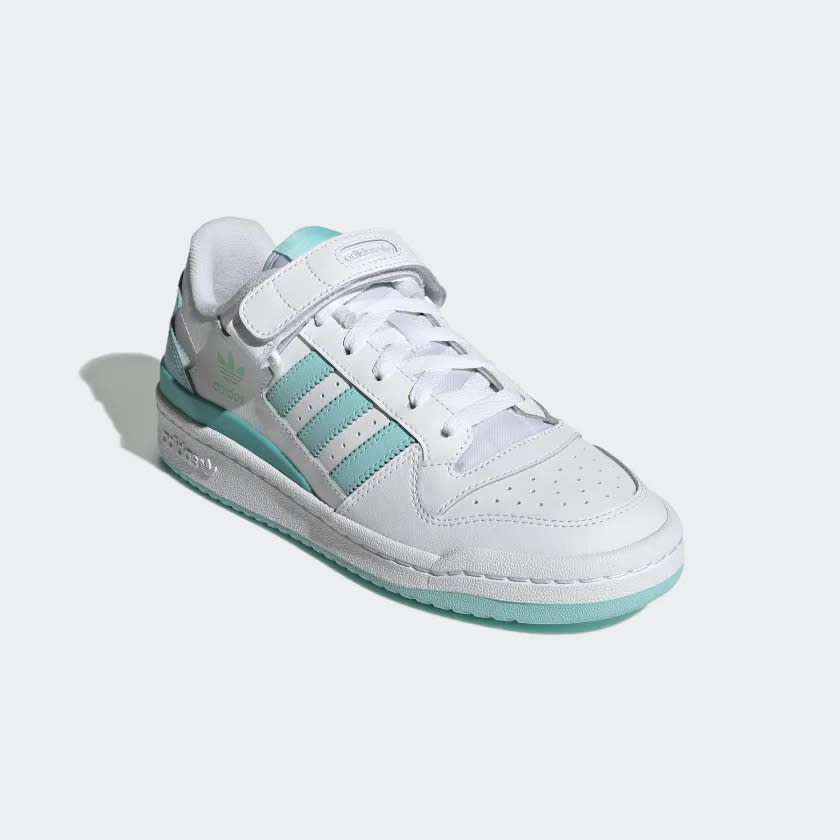 White sneaker with seafoam green sole and three stripes.