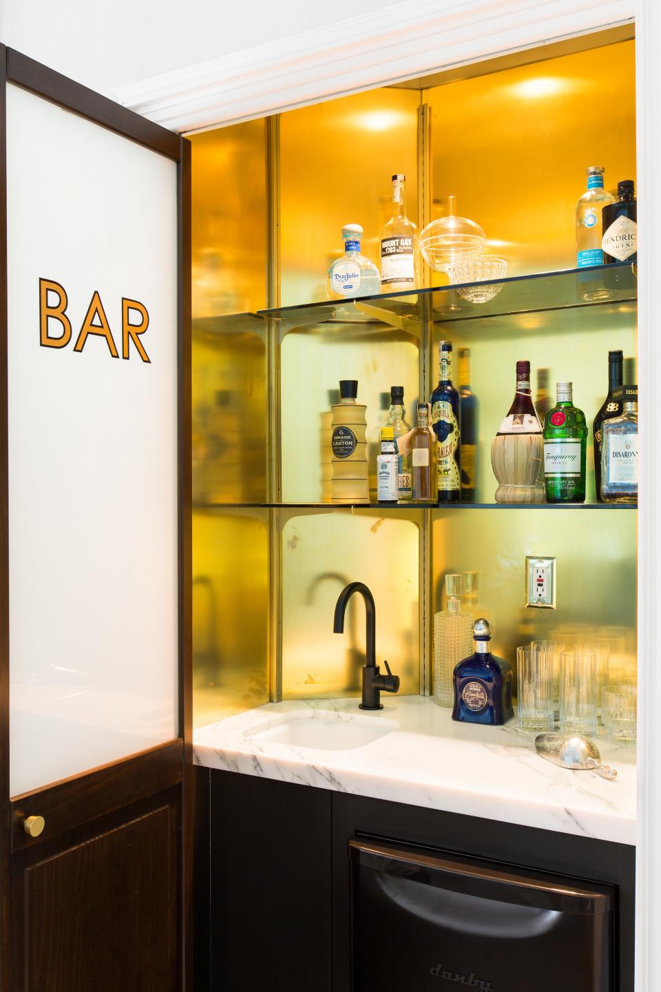 “A friend came over the other night and saw the house and said, ‘Wow, this is like the coolest hotel ever.’ And that was exactly what Katie and I wanted to hear at the end of this process," says Shapiro. A stylized bar sits outside the living room for easy access.