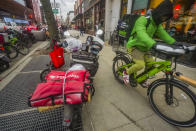 A food delivery worker rides off after a pickup from a fast-food restaurant on Brooklyn's Flatbush Avenue, Monday, Jan. 29, 2024, in New York. A wage law in New York City meant to protect food delivery workers is getting backlash from app companies like Uber, GrubHub and DoorDash, who have cut worker hours and made it more difficult to tip. (AP Photo/Bebeto Matthews)