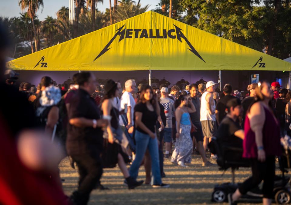 Festivalgoers pass by the Metallica merchandise tent at Power Trip Music Festival at the Empire Polo Club in Indio, Calif., Sunday, Oct. 8, 2023.