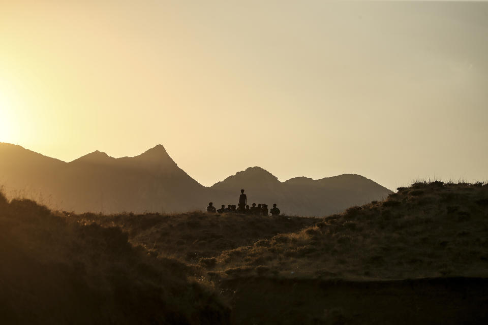 Young men who say they deserted the Afghan military and fled to Turkey through Iran sit in the countryside in Tatvan, in Bitlis Province in eastern Turkey, Tuesday, Aug. 17, 2021. Turkey is concerned about increased migration across the Turkish-Iranian border as Afghans flee the Taliban advance in their country.(AP Photo/Emrah Gurel)