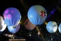 Performers dangling from balloons rise into the air during the Opening Ceremonies of the Copa America 2015 soccer tournament at the National Stadium in Santiago, Chile June 11, 2015. REUTERS/Henry Romero