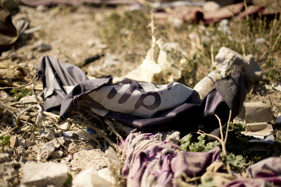 FILE - In this March 23, 2019, file, photo, an Islamic State militant flag lies in a tent encampment after U.S.-backed Syrian Democratic Forces (SDF) fighters took control of Baghouz, Syria. In a video released on April 29, IS leader Abu Bakr al-Baghdadi extolled militants in Sri Lanka for “striking the homes of the crusaders in their Easter, in vengeance for their brothers in Baghouz." (AP Photo/Maya Alleruzzo, File)