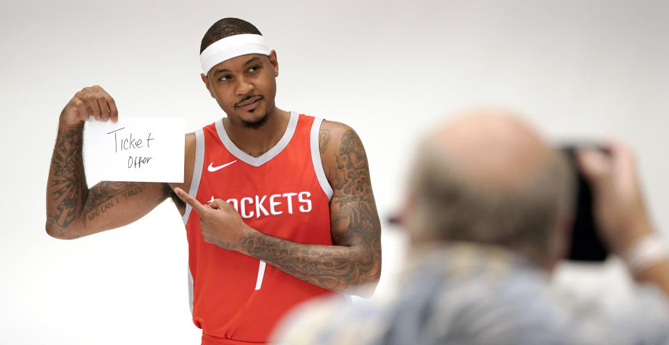 Houston Rockets' Carmelo Anthony holds up a sign while posing for a photographer during media day Monday, Sept. 24, 2018, in Houston. (AP Photo/David J. Phillip)