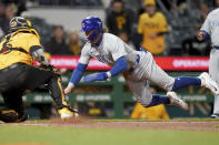 Chicago Cubs' Nico Hoerner, front right, slides into home plate to score against Pittsburgh Pirates catcher Yasmani Grandal , left,during the fifth inning of a baseball game Friday, May 10, 2024, in Pittsburgh. (AP Photo/Matt Freed)