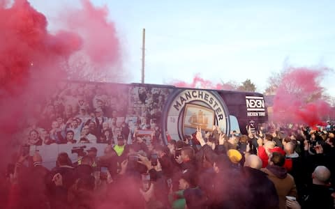 Liverpool fans let off smoke bombs as the Manchester City team bus arrives at the stadium - Credit: Action Images via Reuters/Carl Recine