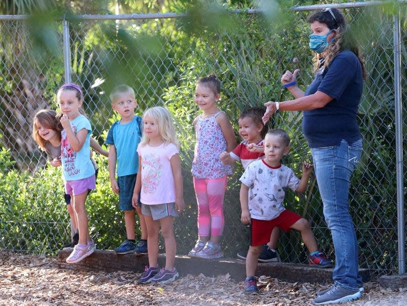 Teacher Marjorie Jackson gets a group of children lined up for a game May 17 at the Imagination Station Montessori child care facility in Daytona Beach, Fla. Jackson keeps her mask on in accordance with CDC recommendations for child care providers.