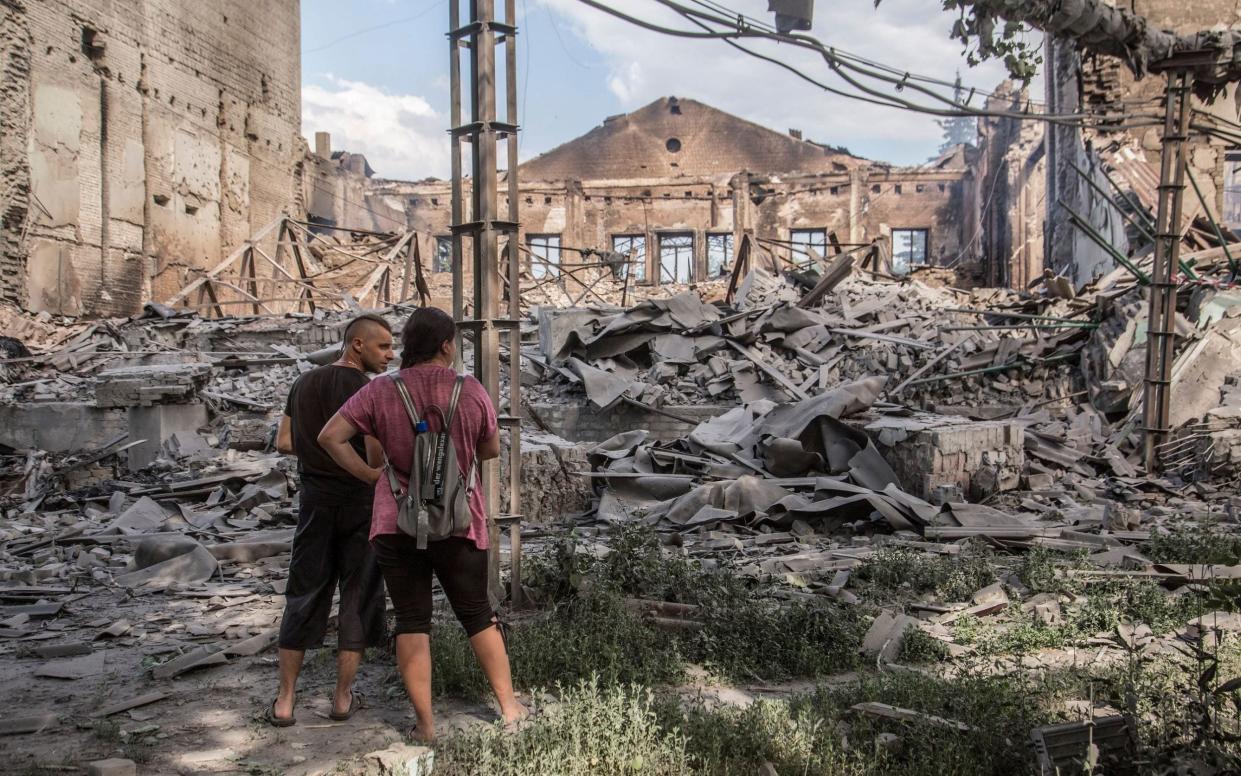 Locals look at destroyed buildings in Lysychansk 
