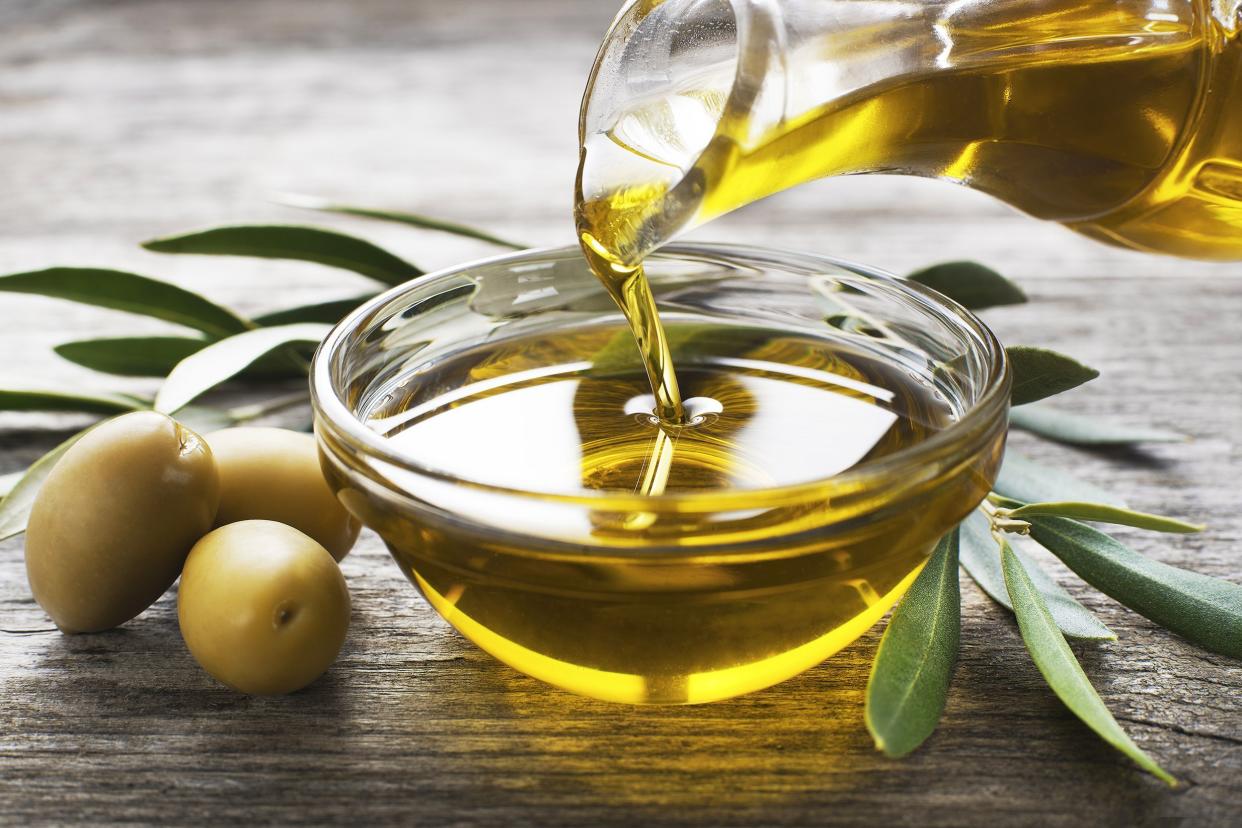 bottle pouring virgin olive oil in a bowl