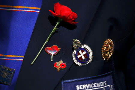 A representative of an ex-servicemen's organisation wears a poppy flower and badges during a memorial service at the ANZAC Memorial to mark the centenary of the Armistice ending World War One, in Sydney, Australia, November 11, 2018. REUTERS/David Gray