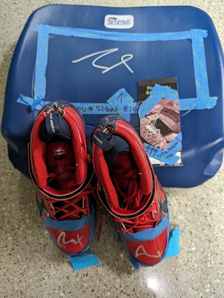 Pictured are Tom Brady's signed game-worn cleats from the 2018 NFL season and a signed seat back from Gillette Stadium designed for New England Patriots owner Robert Kraft in 2002.