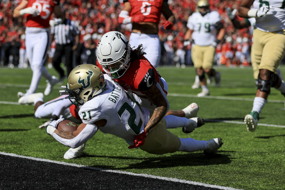 South Florida running back Brian Battie, left, carries the ball for a touchdown as he is tackled by Cincinnati linebacker Deshawn Pace during the first half of an NCAA college football game, Saturday, Oct. 8, 2022, in Cincinnati. (AP Photo/Aaron Doster)