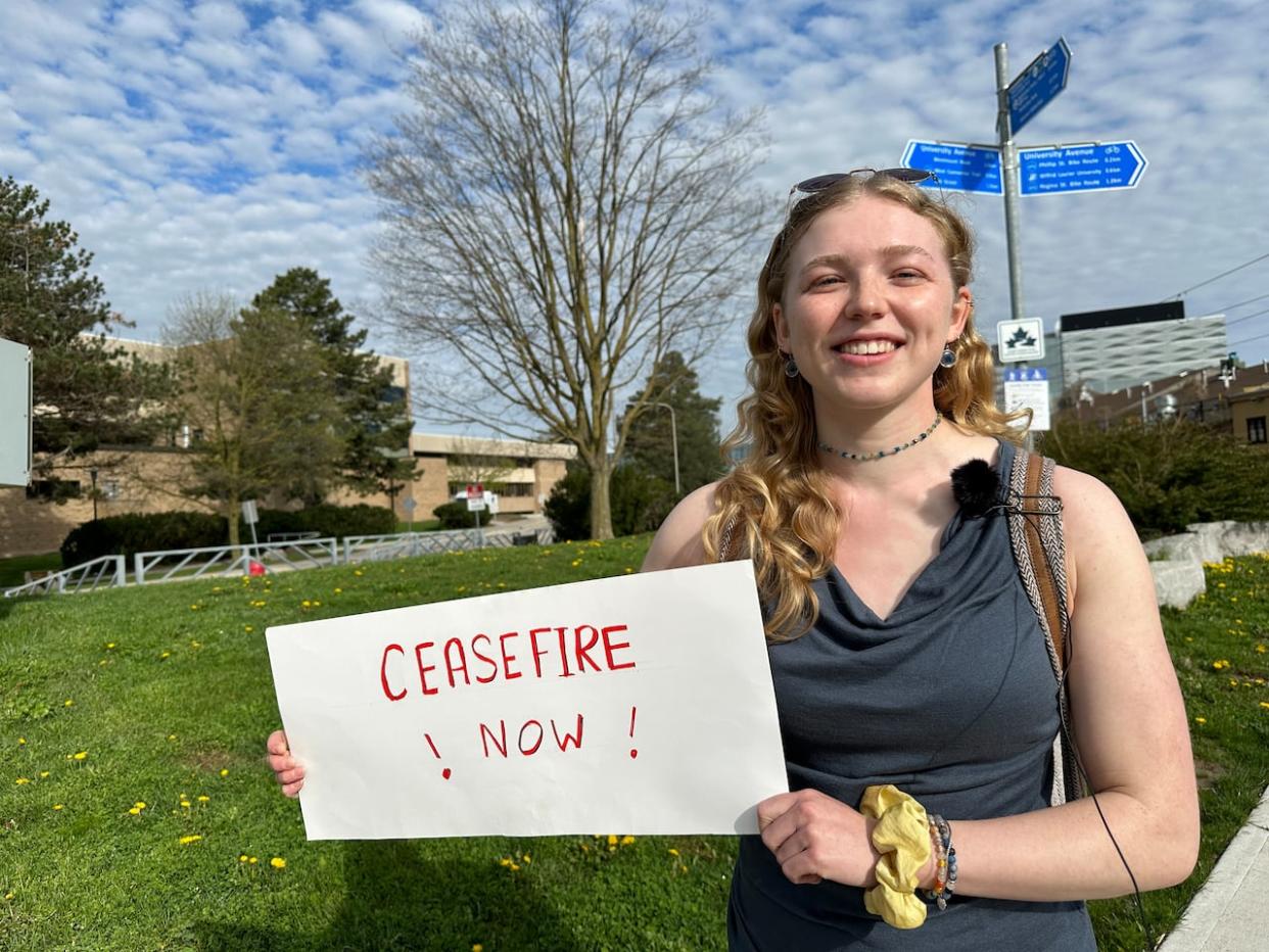 One of the protesters at Wednesday's rally at the edge of the University of Waterloo campus.  (James Chaarani/CBC - image credit)