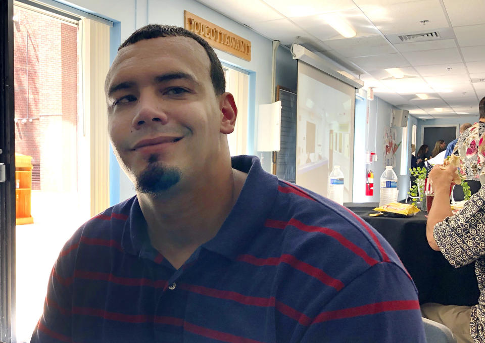 In this Aug. 5, 2019 photo, Cory Johnson sits at a luncheon celebrating the one-year anniversary of the Hampden County Sheriff's Department's minimum security, residential treatment facility in Springfield, Mass. The 35-year-old Holyoke resident is recovering from heroin addiction after recently completing a stay at the facility. Sheriff Thomas Cocchi and his supporters have said the program, one of just three in the state treating civilly committed men and the only in western Massachusetts, can play a key role in efforts to curb the Springfield area's opioid problem. But civil rights group want the practice of imprisoning men for addiction treatment ended. (AP Photo/Philip Marcelo)