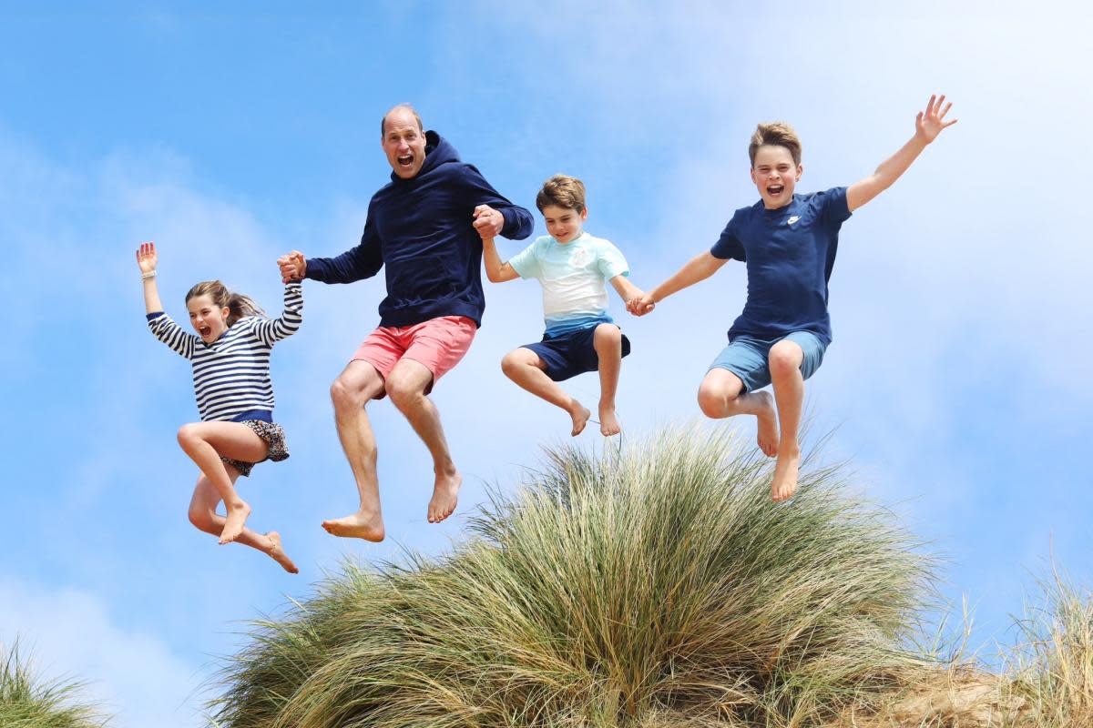 The image, released alongside a message wishing The Prince of Wales a happy 42nd birthday, shows the future king jumping alongside his three children <i>(Image: PA)</i>