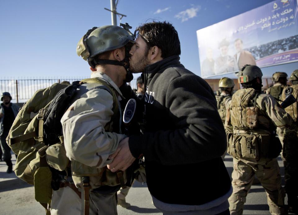 An Afghan special forces soldier, left, is kissed by an Afghan man after the commandos took over control of an election office after the Taliban launched an assault with a suicide bomber detonating his vehicle outside an election office in Kabul, Afghanistan, Tuesday, March 25, 2014. Gunmen stormed into the building, trapping dozens of employees inside and killing many people. A candidate for a seat on a provincial council was among those killed, along with an election worker, a civilian and a policeman. (AP Photo/Anja Niedringhaus)