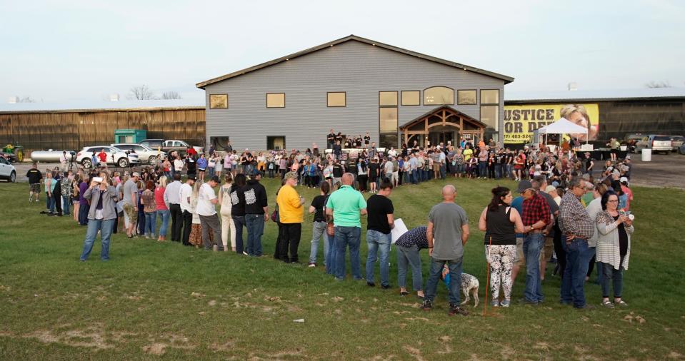 People gathered in the shape of a heart to pray and light candles during the vigil April 23, 2022, at Hardy Farm in Tipton for missing Dee Ann Warner.