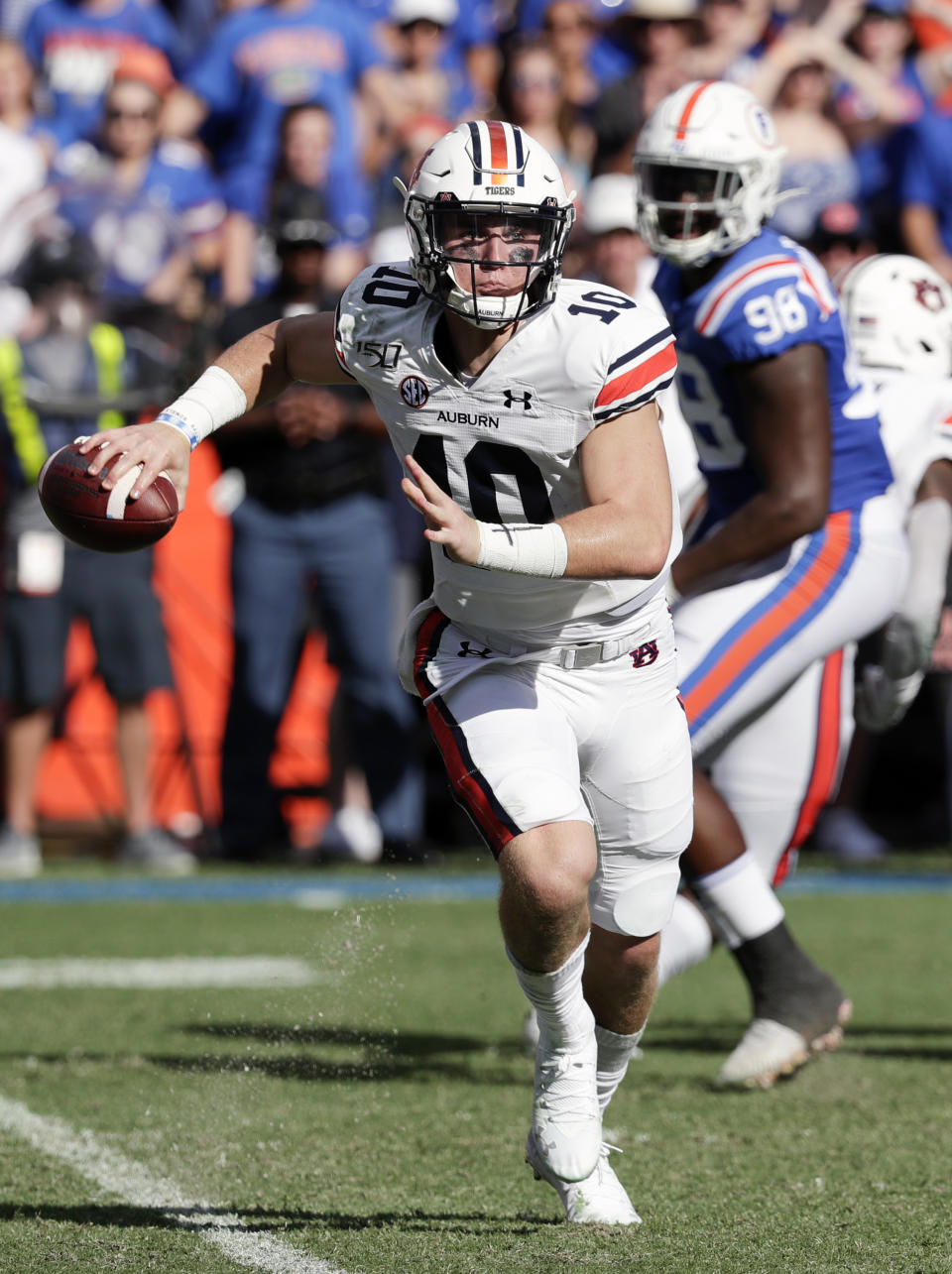 Auburn quarterback Bo Nix, left, looks for a receiver as he is rushed by Florida defensive lineman Luke Ancrum (98) during the first half of an NCAA college football game, Saturday, Oct. 5, 2019, in Gainesville, Fla. (AP Photo/John Raoux)