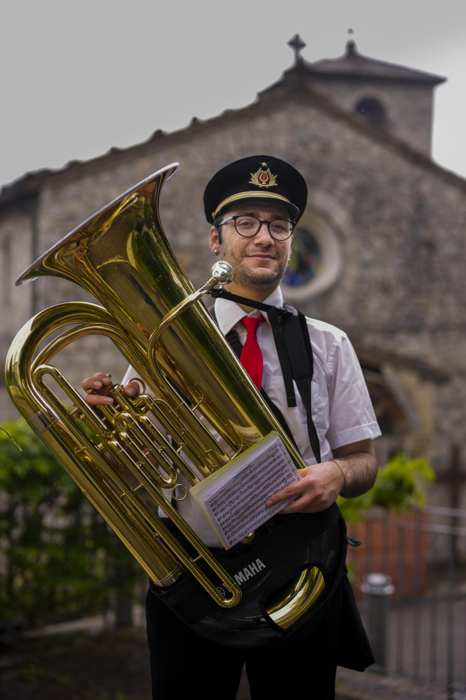 Agostino Tatulli poses with his instrument in Forca di Valle, near Teramo in central Italy, Monday, June 5, 2023. For Tatulli, a way to find meaning is music, including gigs with a marching band for the popular feasts of patron saints. This summer, he participated in two such processions over 48 hours. A weekday morning one was cut short by a rainstorm in the hamlet of Forca di Valle, high on the forested mountain ridge above Isola del Gran Sasso. (AP Photo/Domenico Stinellis)