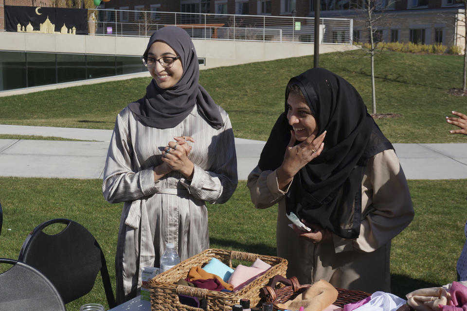 University of St. Thomas graduating senior Salma Nadir (standing, left) and Muslim chaplain Sadaf Shier (standing, right) talks with students attending the school's celebration for the end of the Muslim holy month of Ramadan in St. Paul, Minn., on Saturday, May 7, 2022. Growing numbers of college students across the US are struggling with anxiety and stress, and campus ministry offices are broadening their mission to address the crisis. (AP Photo/Giovanna Dell'Orto)