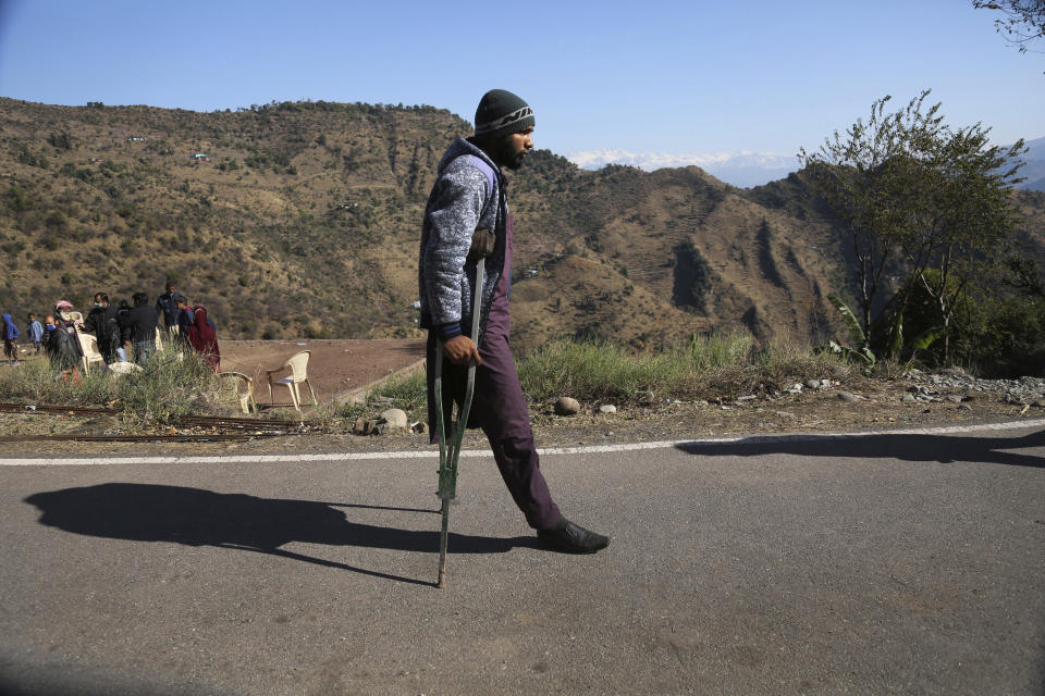 Mohammed Shokat, who lost his leg in cross0firing between India and Pakistan, walks with the help of a crutch in Poonch, India, Wednesday, Dec. 16, 2020. The terrain along the Line of Control, that for the past 73 years divided the region between the two nuclear-armed rivals of India and Pakistan, is tough and the life of civilians living in the area is even tougher, with them often caught in the line of fire. Over the last year, troops from the two sides have traded fire almost daily along the frontier, leaving dozens of civilians and soldiers dead. (AP Photo/Channi Anand)