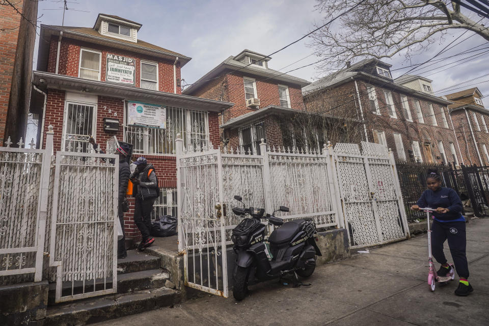 African migrants confer outside a residence that serves as Bronx's Masjid Ansaru-Deen mosque, Friday March 15, 2024, in New York. The mosque, formerly the family home for Imam Omar Niass, has served as a temporary shelter and refuge since 2020 for hundreds of African migrants, while seeking asylum in the United States. (AP Photo/Bebeto Matthews)