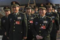 Delegates from China's People's Liberation Army (PLA) share a light moment as they arrive to attend a plenary session of the National People's Congress at the Great Hall of the People in Beijing, Saturday, March 4, 2017. China will raise its defense budget by about 7 percent this year, a government spokeswoman said Saturday, continuing a trend of lowered growth amid a slowing economy. (AP Photo/Andy Wong)