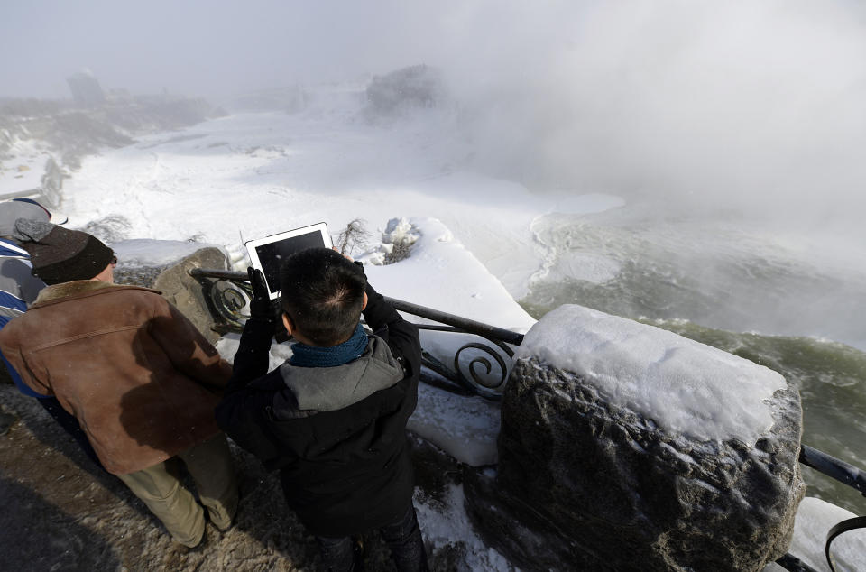 Visitors take pictures overlooking Niagara Falls