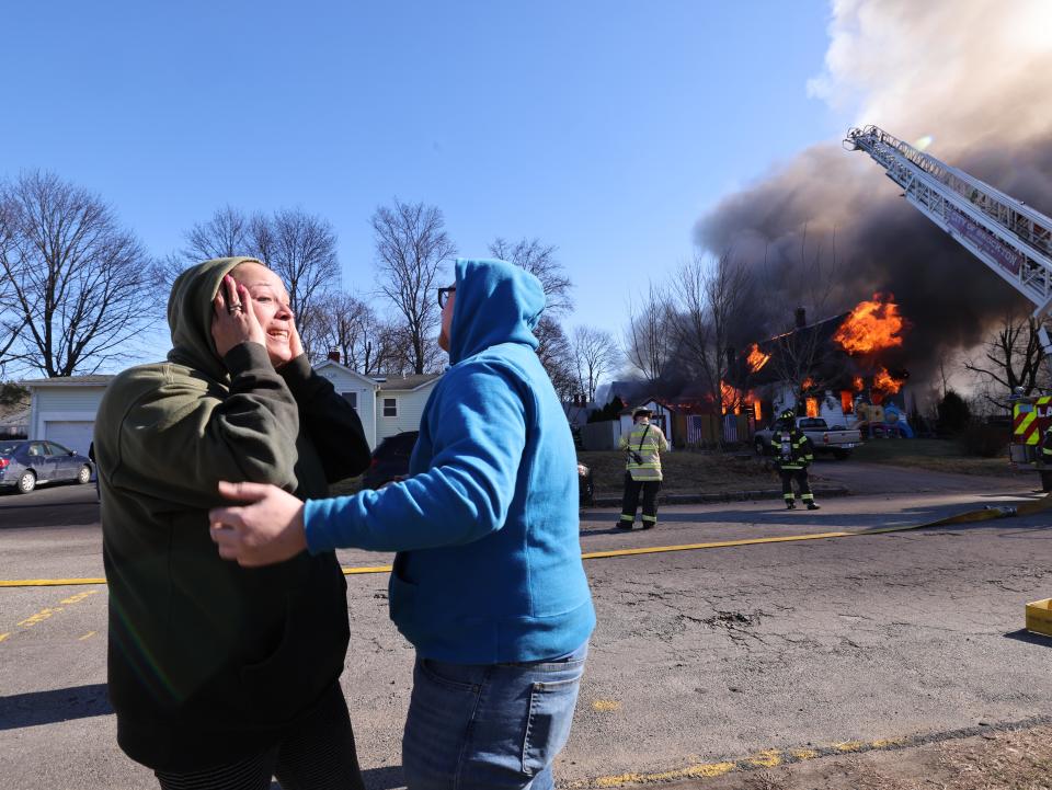 Mandy Adao, left, weeps as she is comforted during a fire at 53 Old Bedford Road in East Bridgewater on Sunday, Feb. 4, 2024. Adao's family lived in one unit in the two-family house and Tina Veronesi Spano lived in the other.