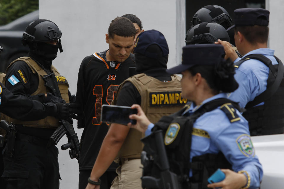 Oficiales de la Dirección Policial Anti Maras y Pandillas contra el Crimen Organizado, DIPAMPCO, trasladan sospechosos en San Pedro Sula, Honduras, el martes 27 de junio de 2023. (AP Foto/Delmer Martínez)