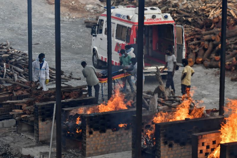 Voluntarios transportan el cuerpo de una persona que murió por COVID-19 a un sector para cremar, en la localidad de Giddenahalli, en las afueras de Bengaluru, India